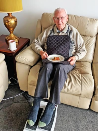 Man wearing adult bib travel napkin eating food