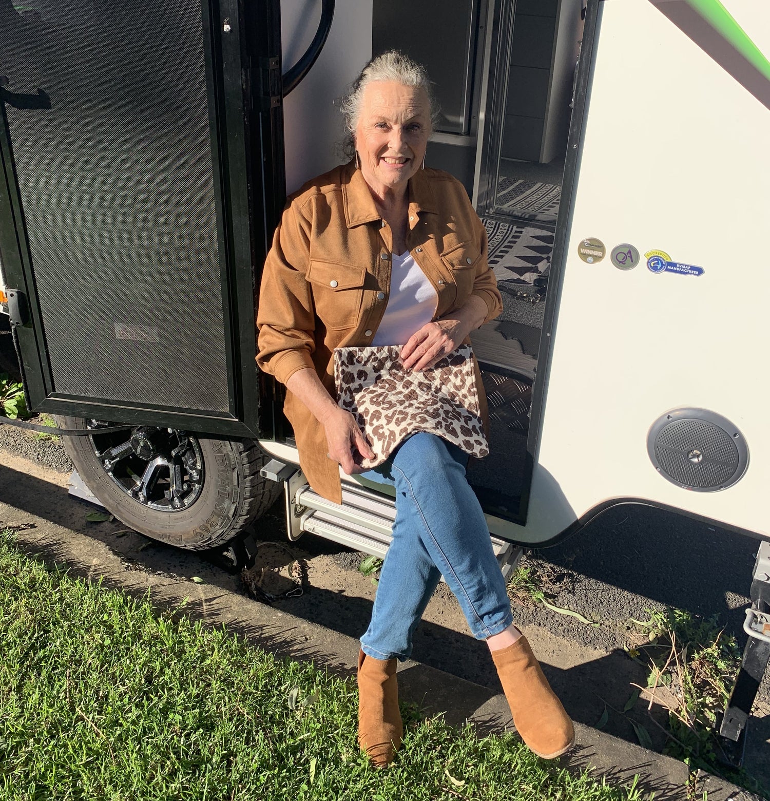Woman sitting on the step of a recreational vehicle with travel napkin